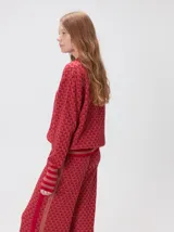 Sweater de punto jacquard con diseño texturizado, cuello alto y puños acanalados en contraste. Presenta un corte holgado y diseño inspirado en patrones naturales.