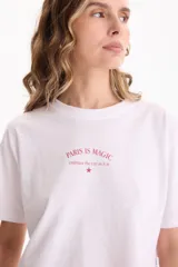 Remera cropped blanca de manga corta y calce cómodo, con estampa frontal en tono rojo con la inscripción "Paris is Magic".