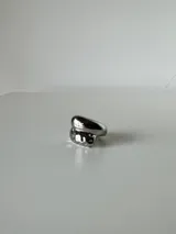 Anillo de acero quirúrgico con diseño asimétrico y superficie texturizada en una de sus partes.