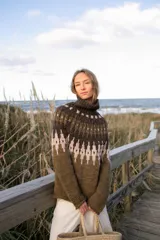 Sweater de lana merino con cuello alto, diseño de tejido artesanal con patrón geométrico en tonos verde oliva, marrón oscuro y beige.