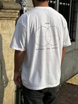 Remera blanca de corte oversize con estampado en la espalda que incluye dos círculos intersecados con las palabras 'Surf', 'Life' y 'Skate', y las frases 'Real Experience', 'Coexist' y 'Meaningful Day'.