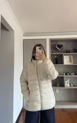 Campera puffer de corte recto y cuello alto, con cierre frontal completo y bolsillos laterales. Diseño acolchado con costuras horizontales.