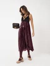 Vestido largo negro con lentejuelas y detalles de encaje, con tirantes finos y escote en V.