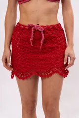 Minifalda tejida a crochet color rojo, con cintura con cordón ajustable rosa.