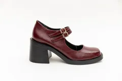 Guillerminas de cuero charol negro con punta cuadrada, taco ancho y correa sobre el empeine con doble hebilla dorada.