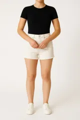 Short de jean color blanco, de tiro medio y corte ajustado al cuerpo, con ruedo deshilachado.