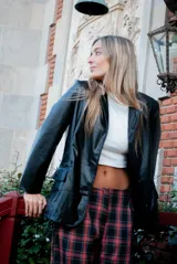 Blazer negro de efecto cuero, con solapas y cierre frontal de botones.
