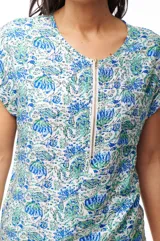 Blusa estampada con flores azules y verdes, de manga corta con cierre metálico en el frente.