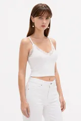 Musculosa blanca de breteles finos y corte corto, con detalle de encaje en el escote en V.