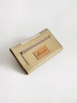 Billetera de cuero con diseño tricolor en tonos neutros, con detalle de costuras decorativas en forma de cruz en la solapa frontal y cierre con broche.