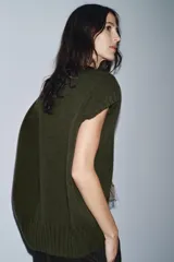 Chaleco oversize de lana color gris, con cuello redondo, manga sisa y bajo asimétrico con aberturas laterales.