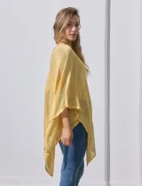 Poncho de tejido calado con acabado brillante, diseño asimétrico y cuello redondo.