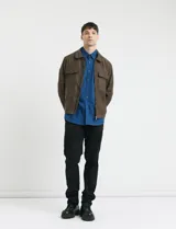 Campera tipo Harrington color oliva, con cierre frontal, cuello clásico y dos bolsillos frontales con solapa.