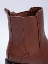 Botas negras de caña media, con plataforma, pieza elastizada en los laterales y detalles de pespuntes.