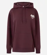 Buzo tipo hoodie color bordó, con corte oversized, capucha ajustable con cordones y bolsillo canguro delantero. Presenta un estampado gráfico pequeño en el pecho con tipografía estilo college.