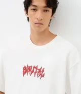 Remera de corte oversized confeccionada en mezcla de algodón y poliéster, con cuello redondo y mangas cortas. Presenta un estampado frontal con lettering estilo gótico y un estampado de esqueleto en la espalda.