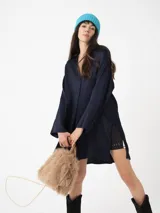 Camisa amplia color blanco, de textura arrugada, con laterales abiertos y detalle de tabla en la espalda.