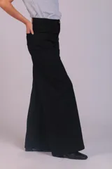 Pantalón de corte wide leg confeccionado en pana acanalada color marrón chocolate. Presenta tiro alto, cierre frontal con botón y bolsillos laterales.