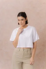 Remera crop color beige, de calce amplio, escote redondo y mangas cortas sueltas.