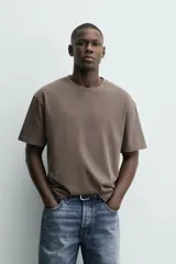 Camiseta de corte relajado confeccionada en algodón con textura irregular, cuello redondo y manga corta.