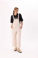 Enterito largo color beige, de corte holgado, con tirantes anchos regulables y bolsillos laterales.