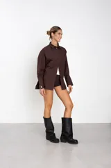 Botas de caña alta confeccionadas en ecocuero negro, con diseño holgado y suela plana con plataforma baja.