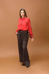 Pantalón sastrero de corte ancho y tiro alto, con diseño de líneas limpias, bolsillos laterales y cierre frontal con botón. Presenta una caída fluida y estructura amplia.