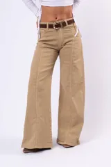 Pantalón wide leg color beige, de tiro medio, con costuras verticales decorativas en el frente y cierre de botón y cremallera.