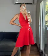Vestido corto rojo con escote halter, espalda descubierta y falda acampanada.