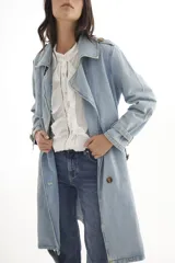 Trench de jean largo con diseño relajado, cuello solapa, cierre frontal con botones y charreteras en los hombros.