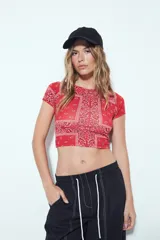 Top crop de manga corta, ajustado al cuerpo, con estampado tipo bandana en tonos rojos y blancos.