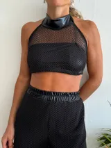 Top negro de red con cuello halter de cuero sintético.