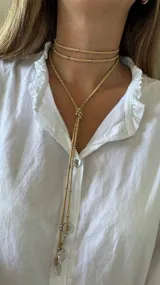 Gargantilla roja de múltiples vueltas con cuentas plateadas y dijes redondos.