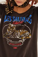 Remera de algodón color gris oscuro con estampa frontal estilo vintage que incluye un tigre, texto en azul y rojo, y diseño gráfico circular.
