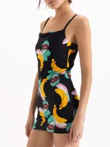 Vestido corto de calce al cuerpo, color negro con estampado frutal de bananas y hojas. Presenta escote recto con breteles finos.