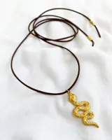 Gargantilla con tiento de cuero marrón y dije de serpiente dorada.