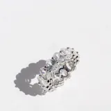Anillo plateado de acero con cristales ovalados engarzados en todo el contorno.