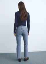 Jeans de tiro medio con diseño flare y bajo deshilachado, con cinco bolsillos, presillas para cinturón y cierre frontal con cremallera y botón.