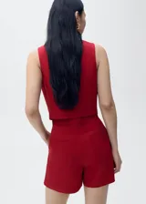 Chaleco de corte sastre con cuello escotado y tirantes anchos. Presenta cierre frontal con botones ocultos bajo tapeta y dos bolsillos de ribete delanteros. Confeccionado en una mezcla de viscosa, lino y algodón con forro interior de algodón.