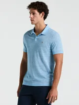 Polo celeste con textura jaspeada, cuello clásico, manga corta y logo bordado en el pecho.