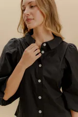 Camisa a rayas verticales rojas y blancas, con cuello bebé, mangas globo 3/4 y botones nacarados.