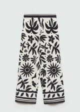 Pantalon de corte wideleg con cintura elastizada, confeccionado en tejido fluido con estampado floral en contraste. Presenta bolsillos laterales y diseño largo.