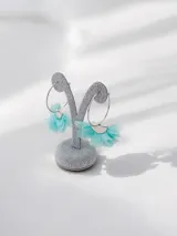 Aros tipo argolla plateados con detalle decorativo en forma de abanico hecho de tela de tul color turquesa.