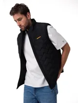 Chaleco negro Caterpillar acolchado con diseño geométrico, cuello alto y cierre frontal con cremallera. Cuenta con logo de la marca estampado en el pecho en color amarillo.