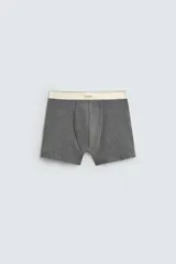 Pack de tres bóxers de hombre en tonos neutros: blanco, gris medio y gris oscuro. Tienen tejido elástico con acabado suave y cintura elástica ancha de color crema con etiqueta central.