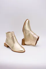 Botín de cuero dorado con punta fina y taco bajo cuadrado de madera.