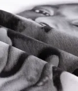 Remera blanca de algodón con cuello redondo, mangas cortas y corte oversized. Presenta un estampado frontal en blanco y negro del rapero Snoop Dogg, con letras góticas en la parte superior.