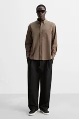 Zapatilla de cordones de caña baja, color negro, con capellada lisa y suela de goma blanca.