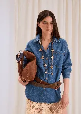 Camisa de denim lavado con corte amplio y hombros caídos, de manga larga y cierre frontal de botones.
