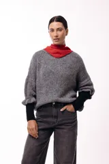 Sweater de punto con silueta relajada, mangas 3/4 abullonadas y cuello redondo. Presenta una textura suave y diseño holgado.